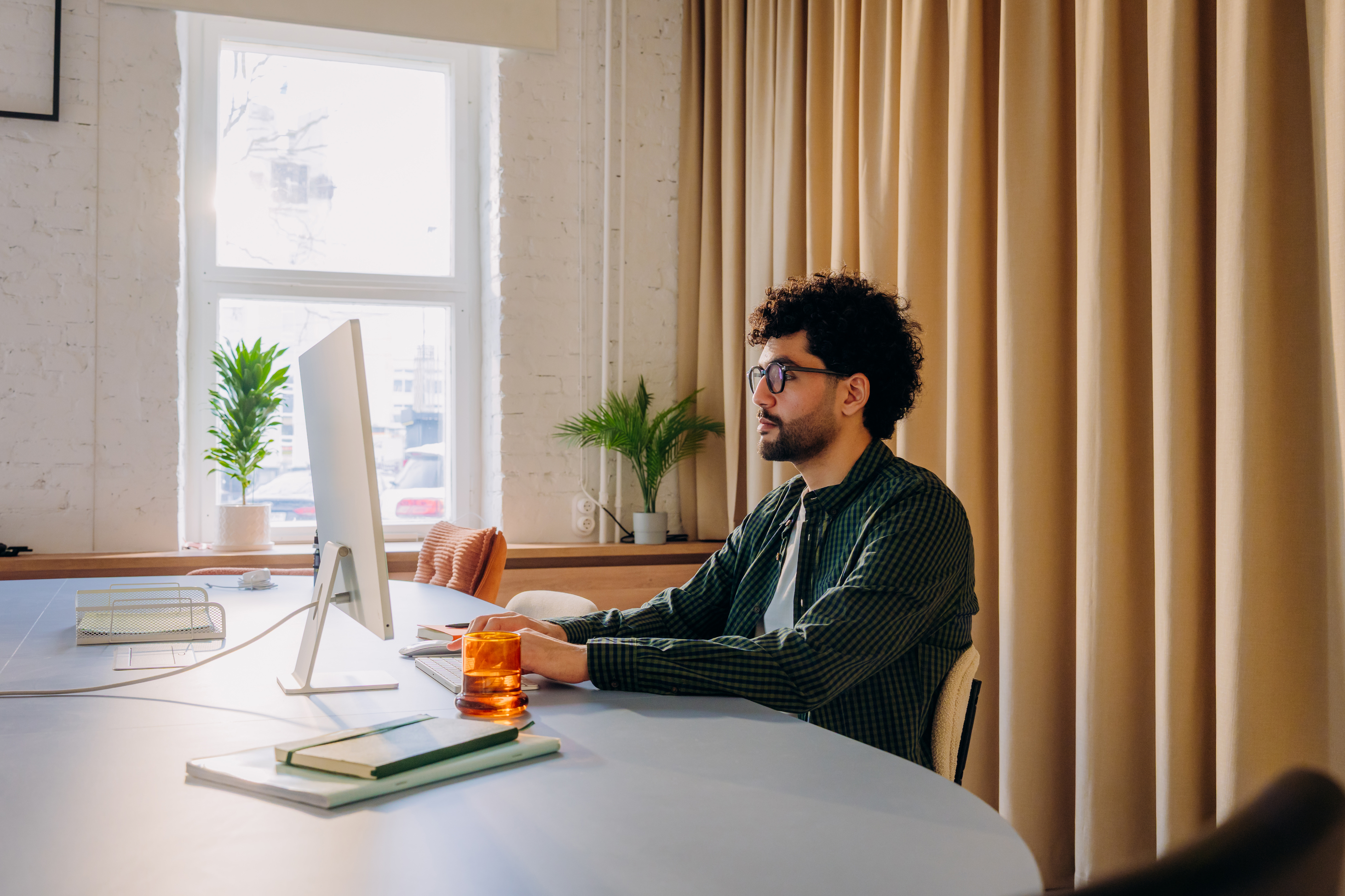 Mann sitzt am Schreibtisch mit Computer